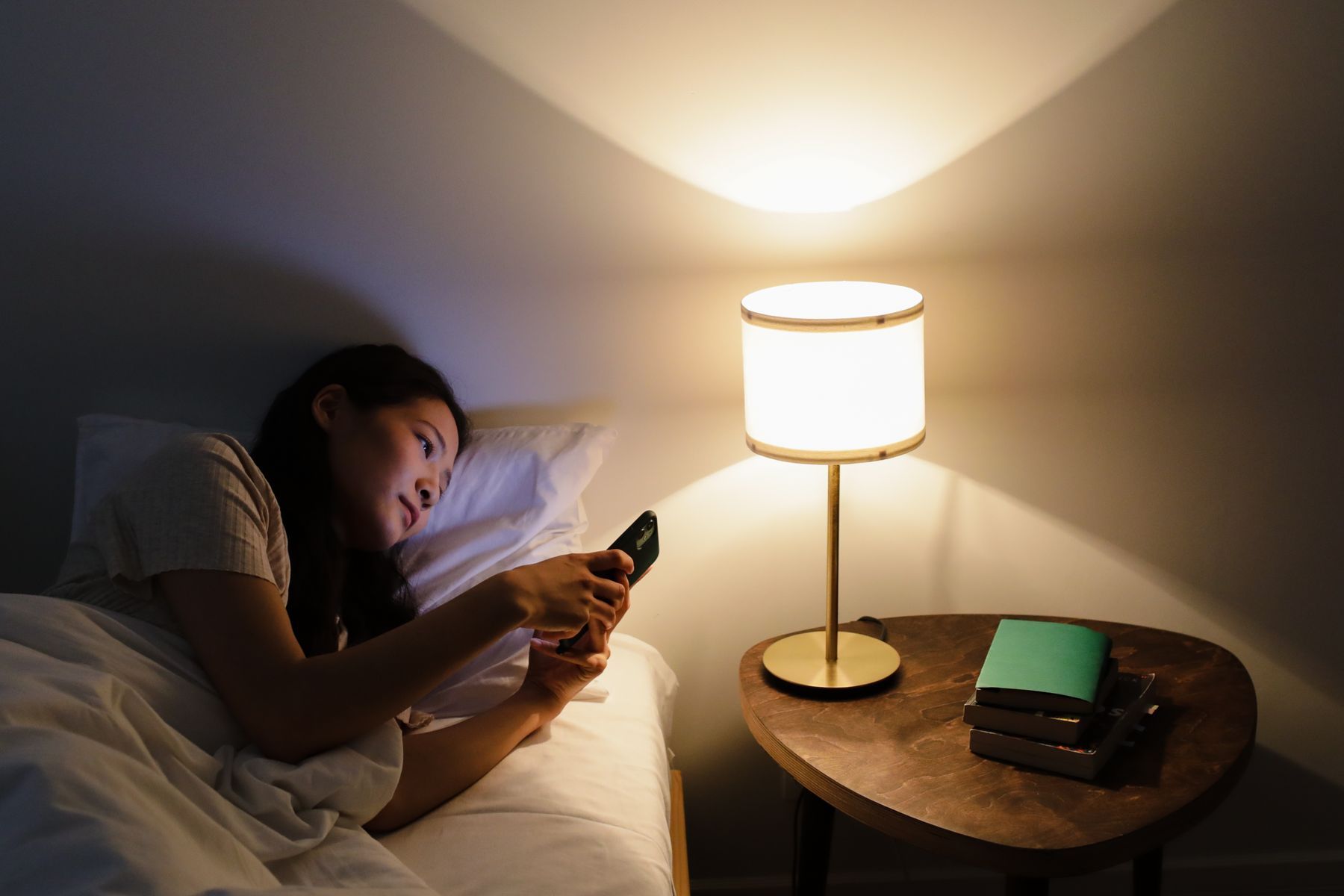Alguien mirando el teléfono en la cama por la noche