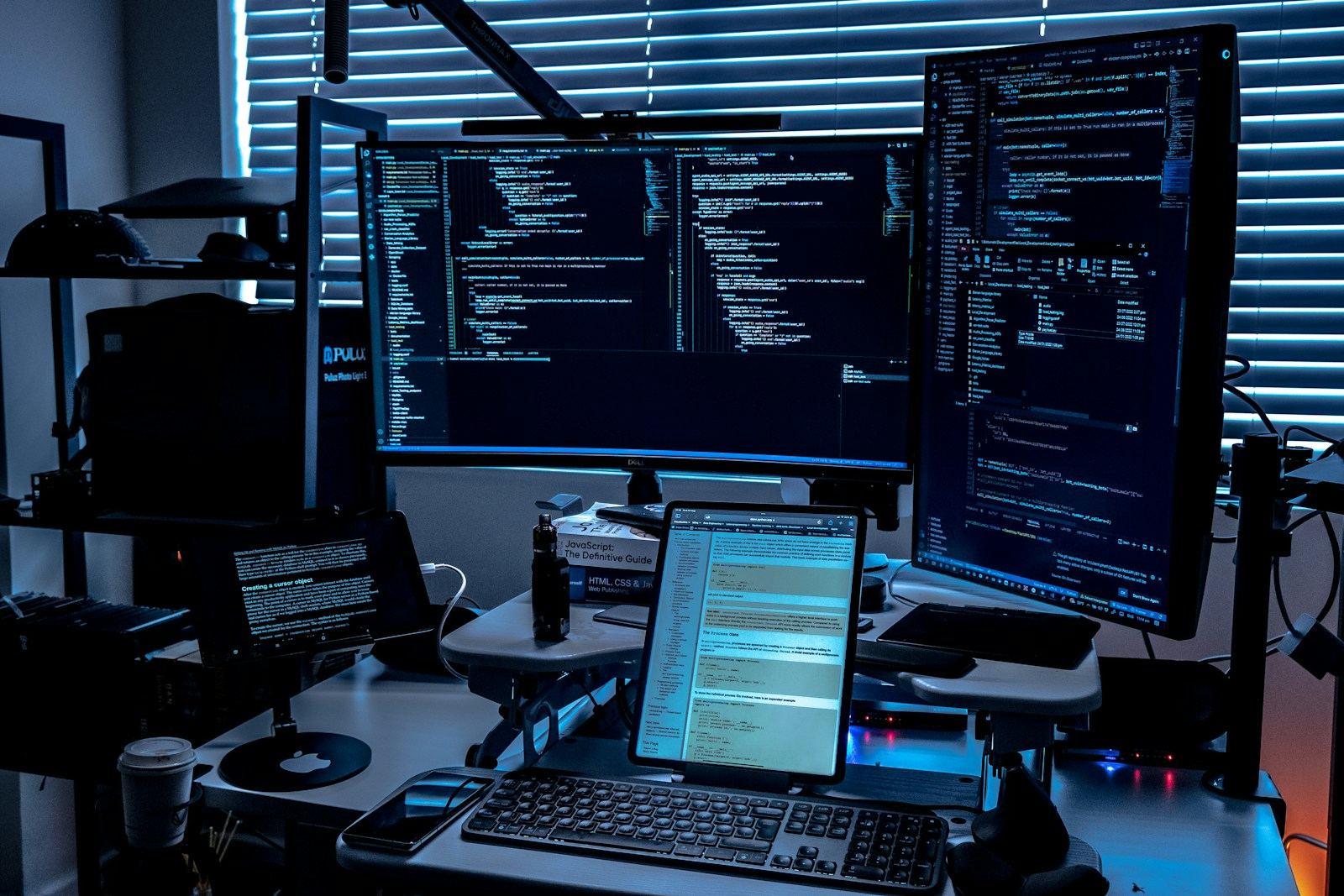 A developer desk with several screens full of code